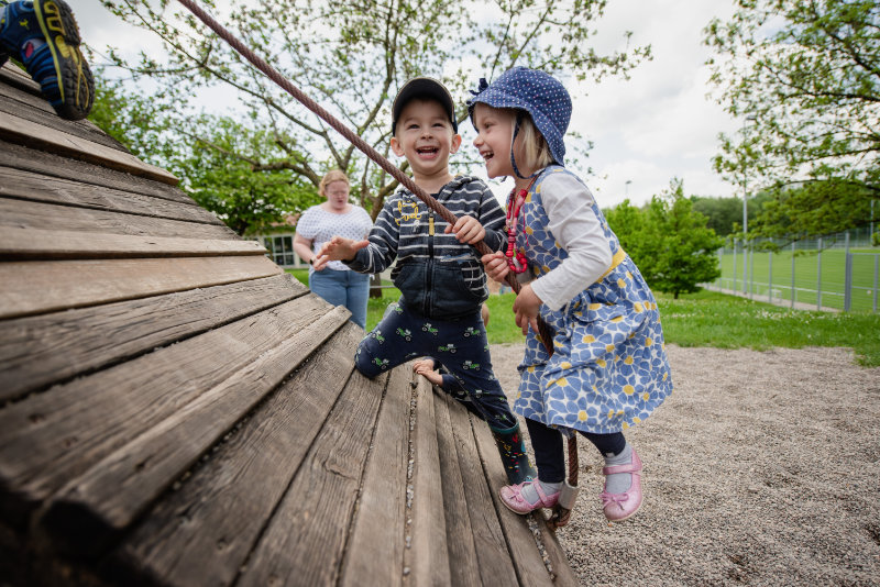 Kinder klettern an schrägwand im Garten