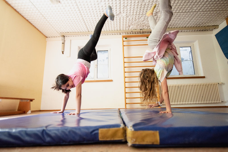 Kinder schlagen ein Rad in der Turnhalle