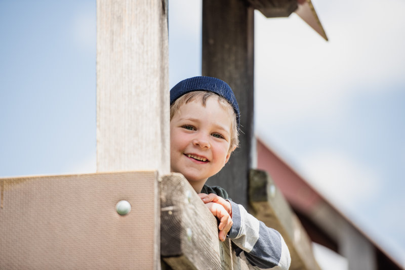 kind schaut vom Kletterturm