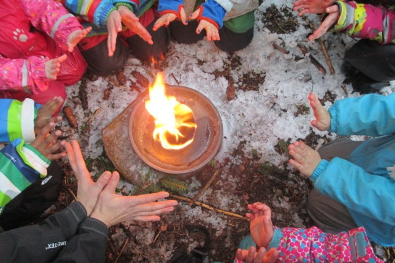 Kinderhände um ein Lagerfeuer